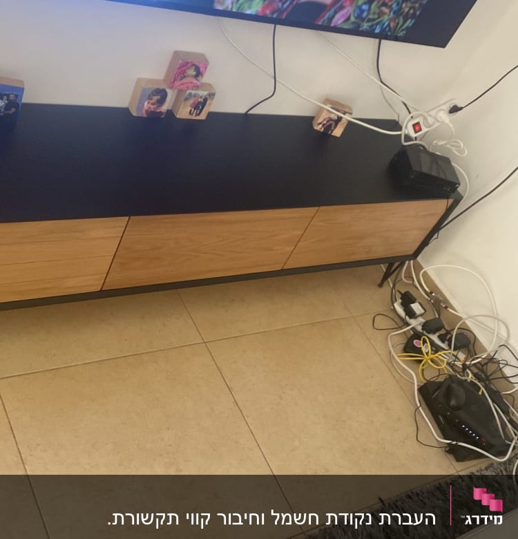 כבלים חשמליים ומפצל חשמל ליד טלוויזיה